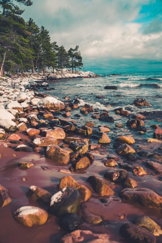 Colorful rocks along a snowy Lake Superior beach in Marquette, Michigan